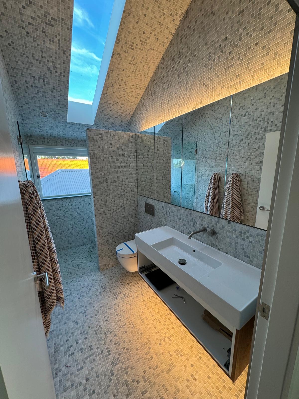 Mosaic-tiled bathroom with skylight