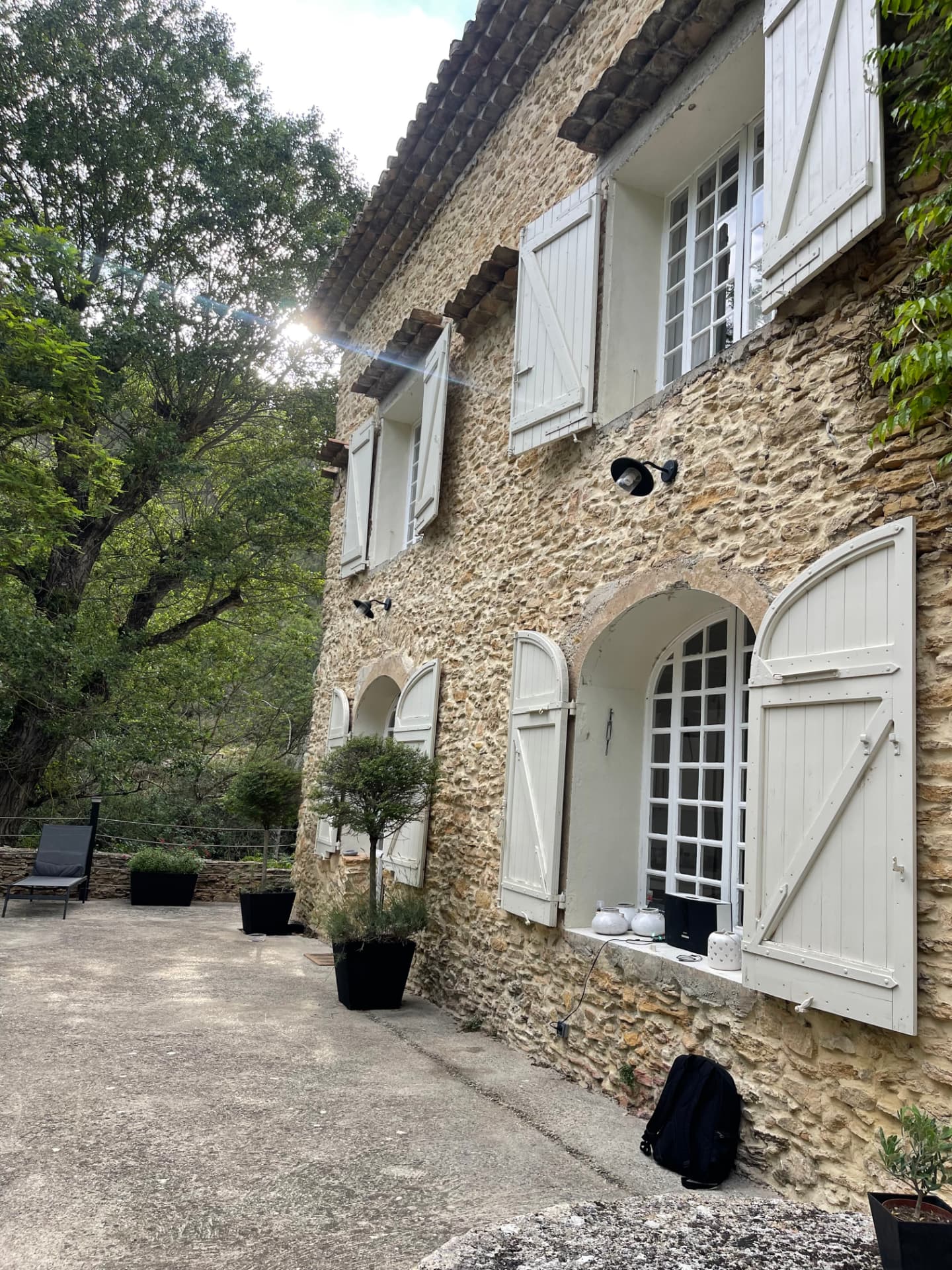 Stone facade with open shutters and arched windows