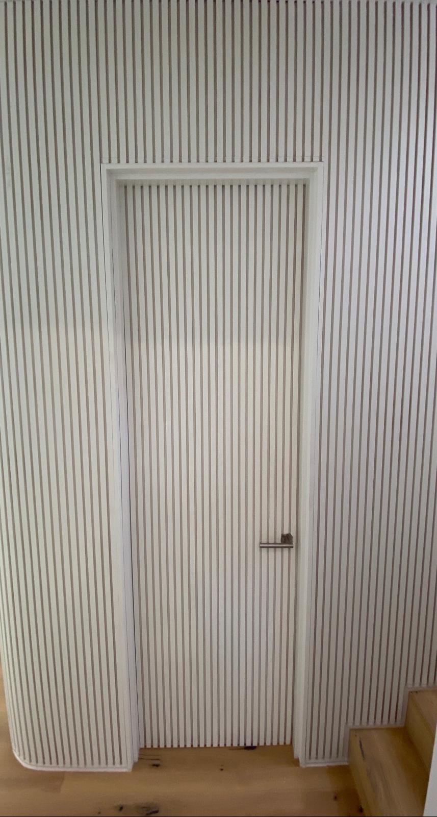 Concealed door within fluted batten joinery