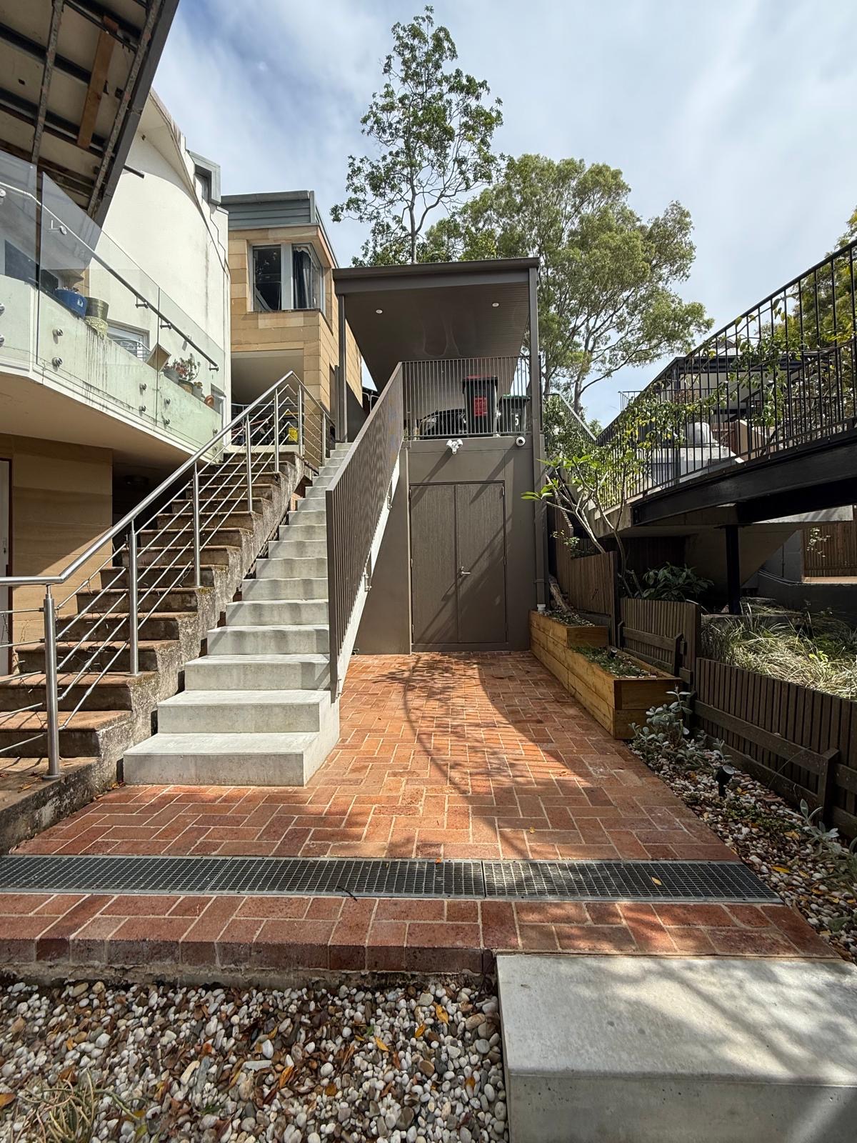 Concrete stair and brick paving to entry