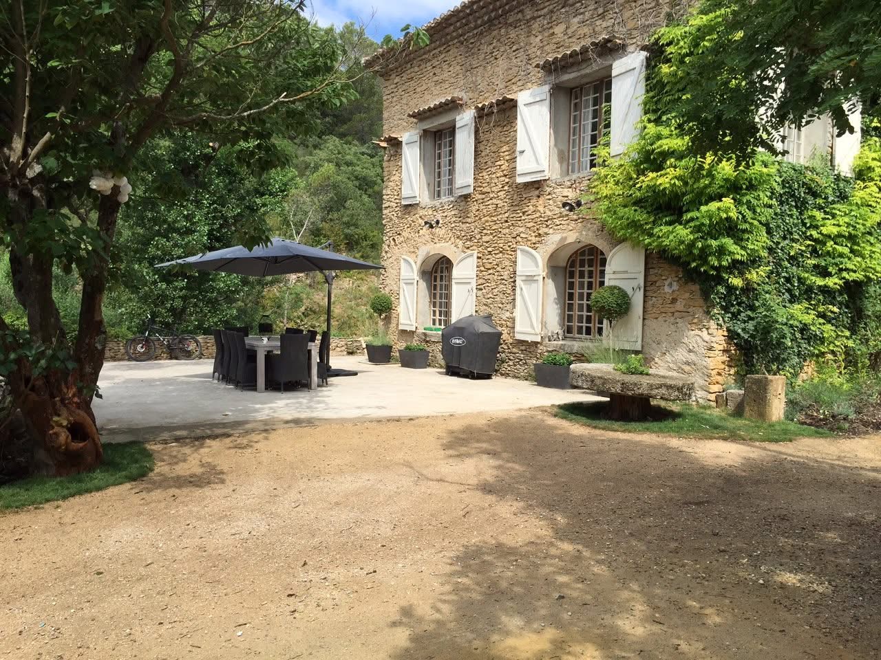Stone facade with shuttered windows and terrace dining