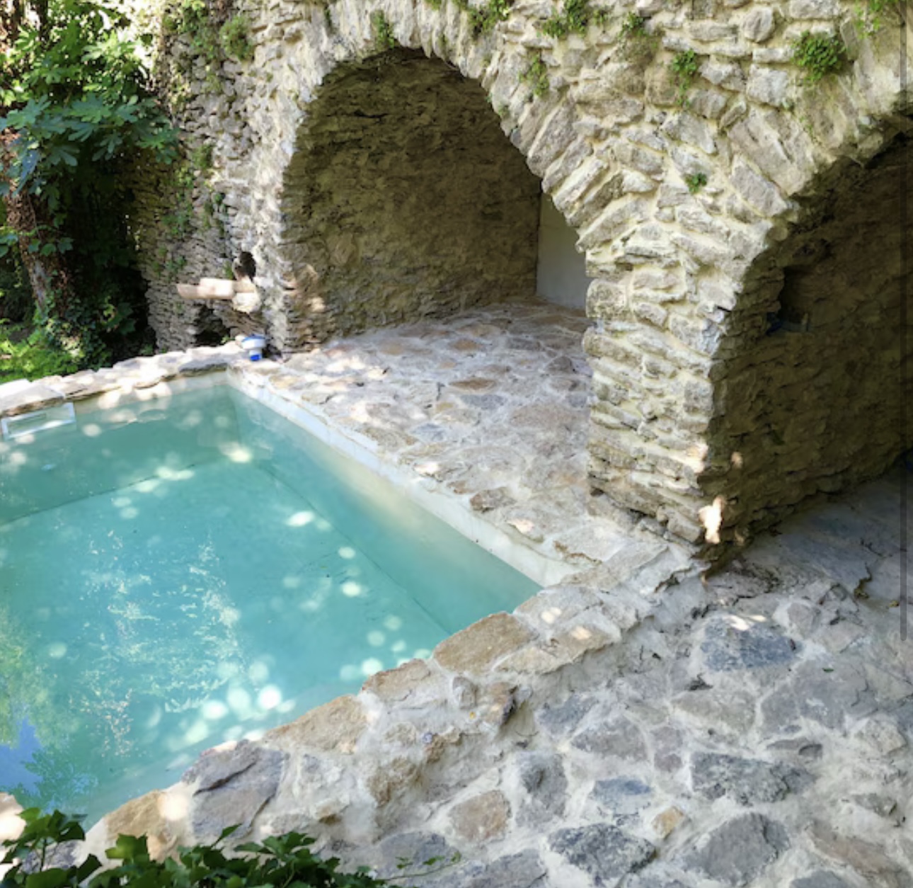 Stone-edged pool beneath a rock arch
