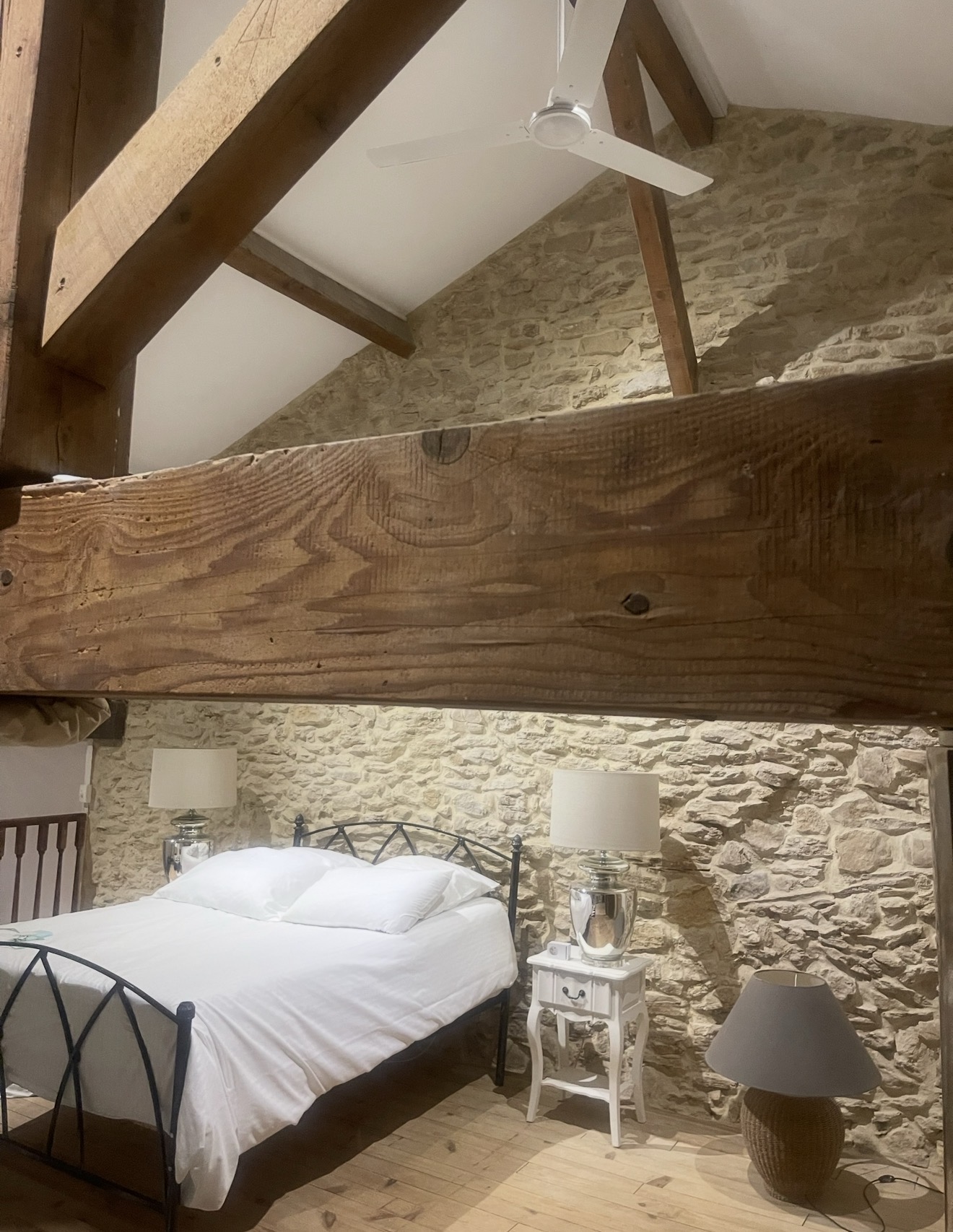 Bedroom with exposed timber beams and stone walls